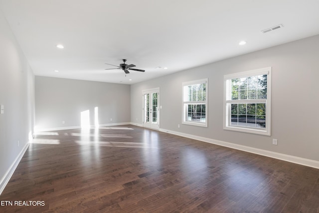 unfurnished living room with baseboards, wood finished floors, visible vents, and a wealth of natural light