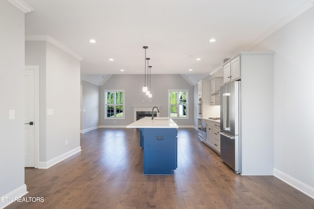 kitchen featuring an island with sink, high end fridge, hanging light fixtures, and dark hardwood / wood-style floors