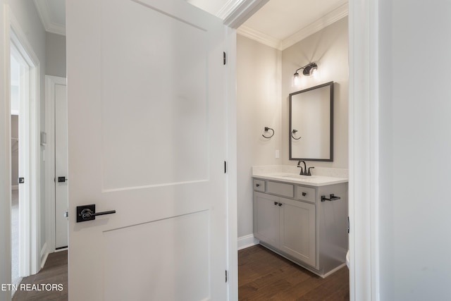 bathroom with crown molding, hardwood / wood-style floors, and vanity