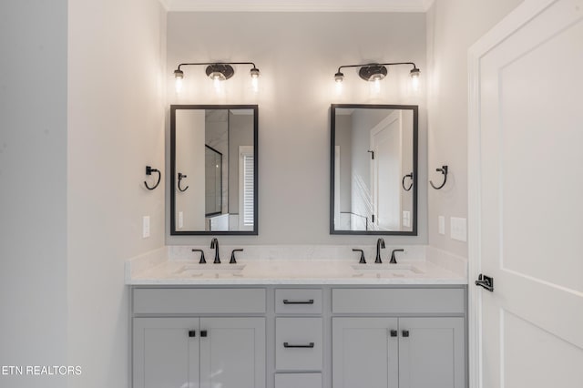full bathroom with double vanity, a shower, ornamental molding, and a sink