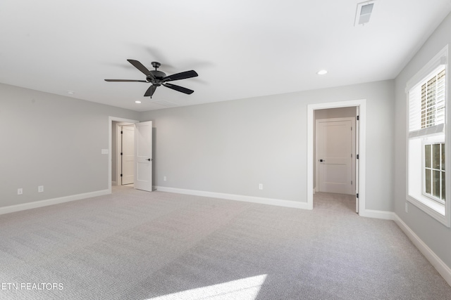 empty room featuring ceiling fan and light carpet