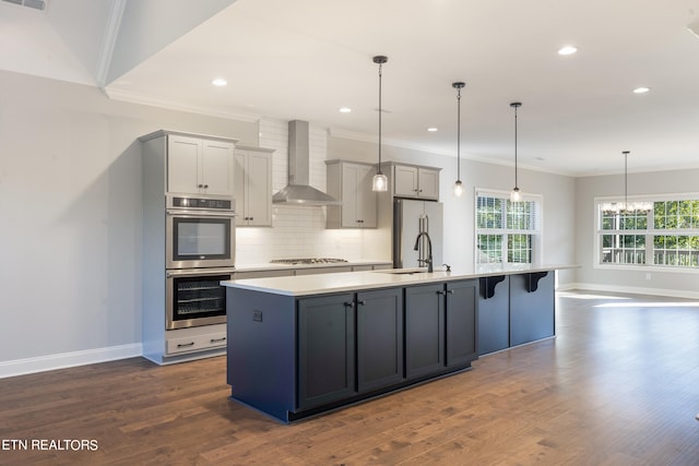 kitchen with wall chimney exhaust hood, stainless steel appliances, dark hardwood / wood-style flooring, and gray cabinetry