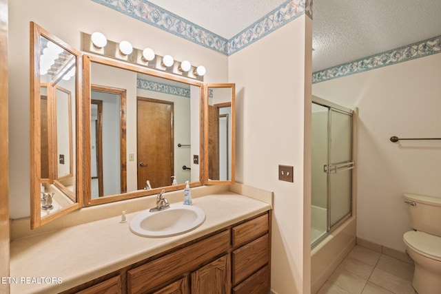 full bathroom with tile patterned floors, toilet, vanity, a textured ceiling, and shower / bath combination with glass door