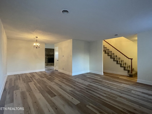 unfurnished living room featuring a notable chandelier and hardwood / wood-style flooring