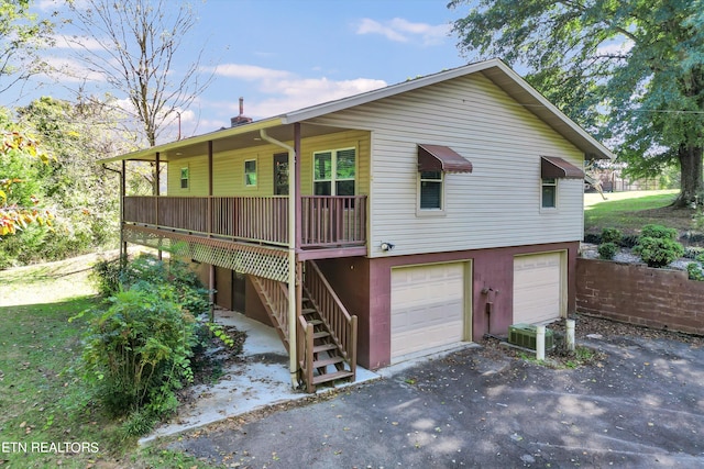 view of front of house with central air condition unit and a garage