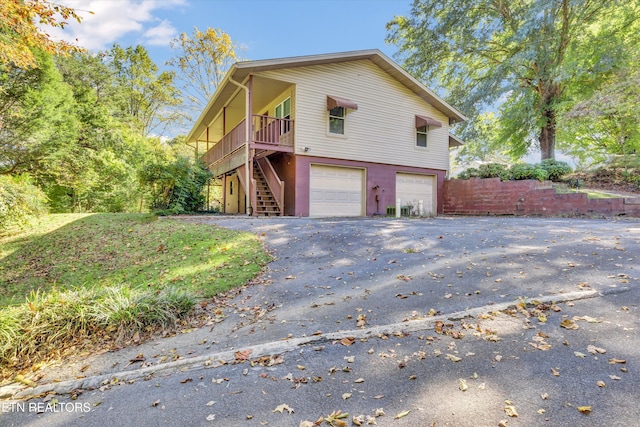 view of side of property featuring a wooden deck and a garage