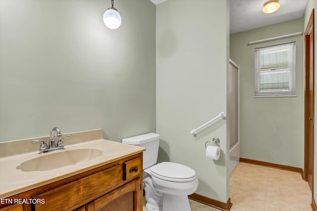 full bathroom featuring vanity, bath / shower combo with glass door, and toilet