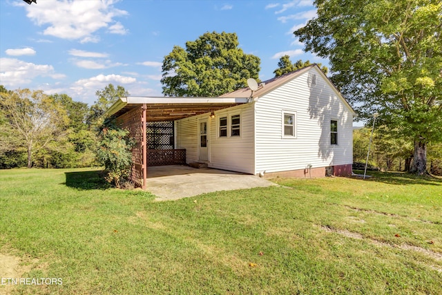 back of house with a carport and a lawn