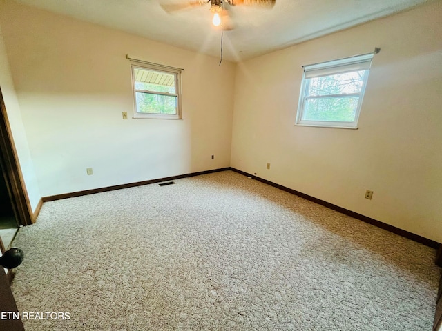 spare room featuring carpet flooring, ceiling fan, and plenty of natural light