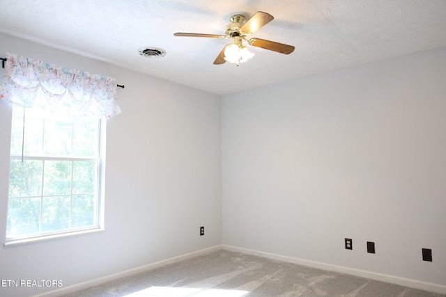 unfurnished room with carpet flooring, a textured ceiling, and ceiling fan