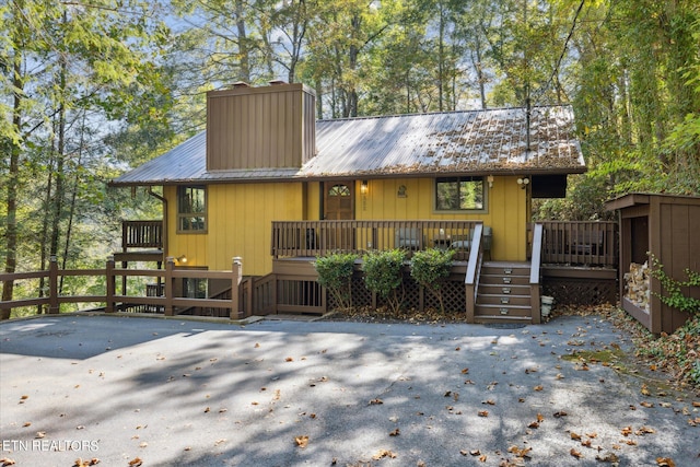 rear view of property featuring a deck