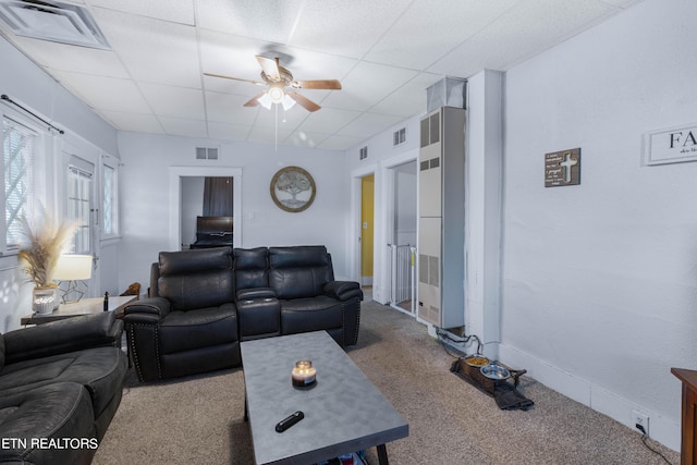 living room featuring carpet floors, ceiling fan, visible vents, and a drop ceiling