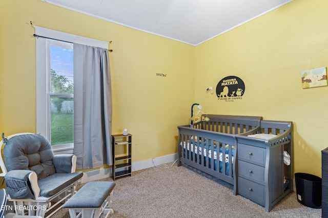 carpeted bedroom featuring crown molding, a crib, and baseboards