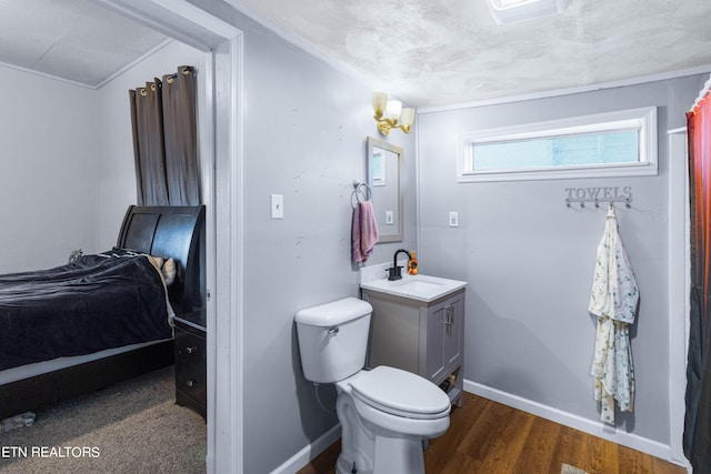 bathroom featuring vanity, wood-type flooring, a textured ceiling, crown molding, and toilet