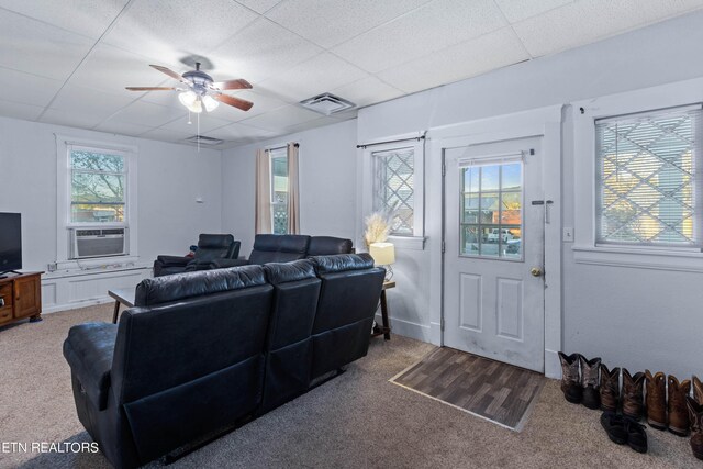 living room featuring ceiling fan, cooling unit, carpet floors, a paneled ceiling, and visible vents
