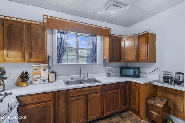 kitchen with a drop ceiling, dark wood-type flooring, sink, and white stove