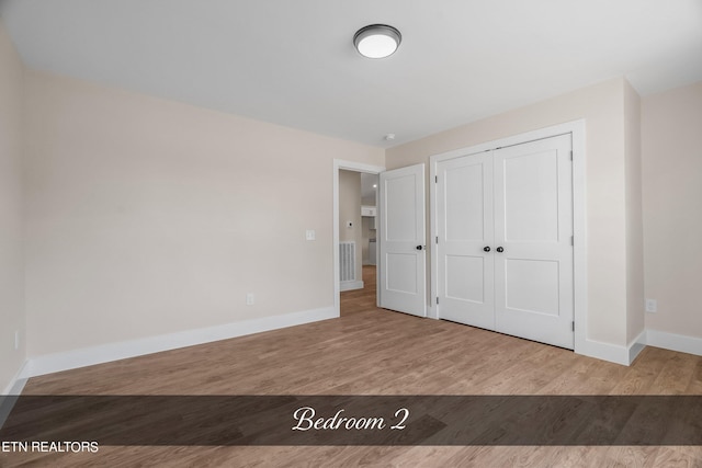 unfurnished bedroom featuring a closet and light hardwood / wood-style floors