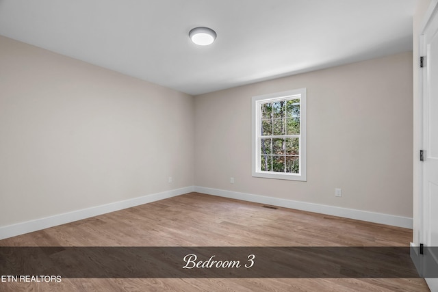 spare room with hardwood / wood-style flooring