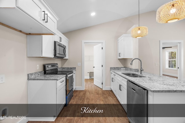 kitchen featuring lofted ceiling, stainless steel appliances, white cabinets, sink, and hanging light fixtures