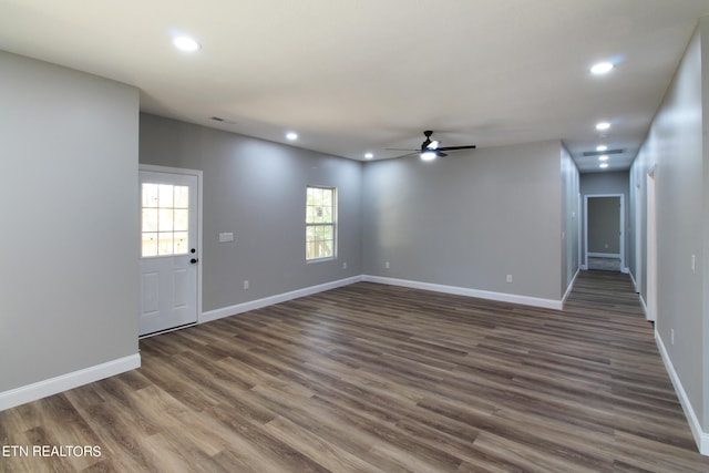 unfurnished living room featuring ceiling fan and dark hardwood / wood-style floors