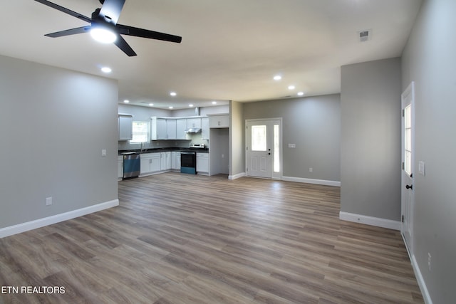 unfurnished living room featuring sink, hardwood / wood-style flooring, and ceiling fan