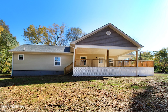 rear view of property with a deck and a lawn