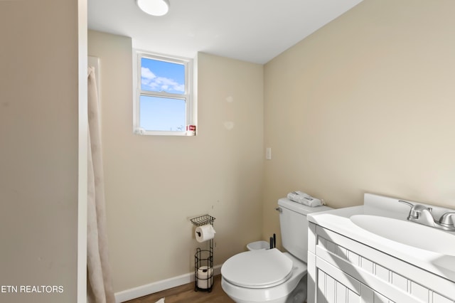 bathroom with wood-type flooring, vanity, and toilet