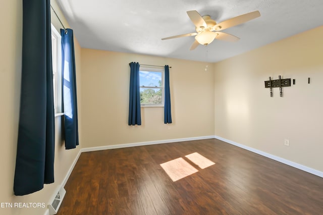 unfurnished room featuring ceiling fan and dark wood-type flooring