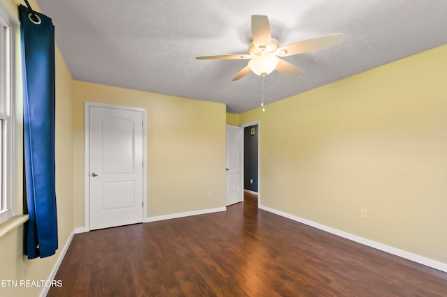 unfurnished room featuring ceiling fan, dark hardwood / wood-style floors, and a textured ceiling