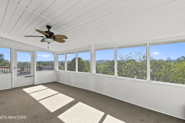 unfurnished sunroom with ceiling fan and vaulted ceiling