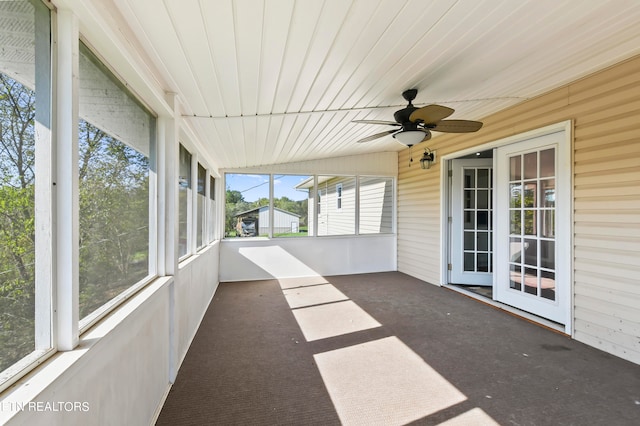 unfurnished sunroom with ceiling fan