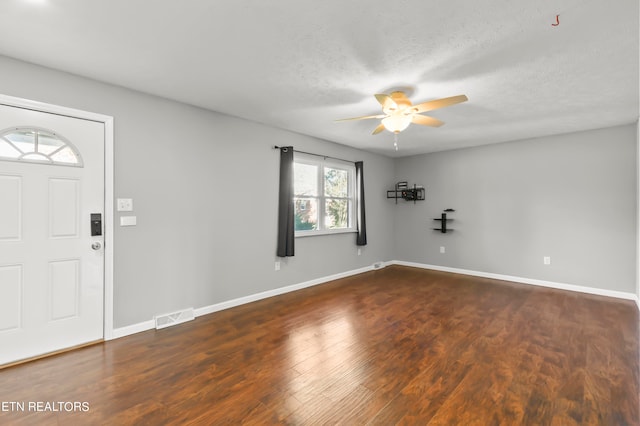 foyer with ceiling fan, a textured ceiling, and dark hardwood / wood-style floors