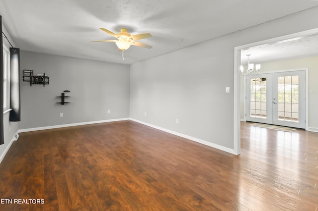 unfurnished room featuring french doors, a textured ceiling, ceiling fan with notable chandelier, and dark hardwood / wood-style flooring