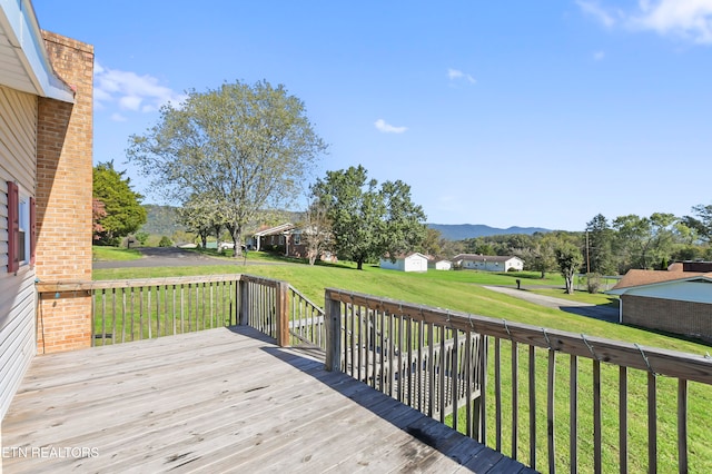 wooden terrace with a lawn and a mountain view