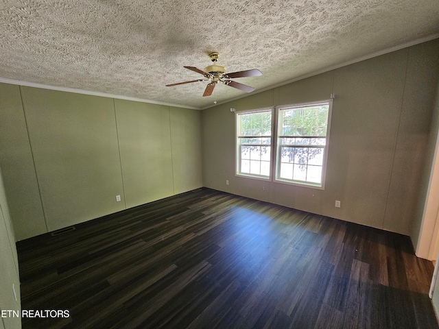 empty room with vaulted ceiling, ceiling fan, crown molding, dark wood-type flooring, and a textured ceiling