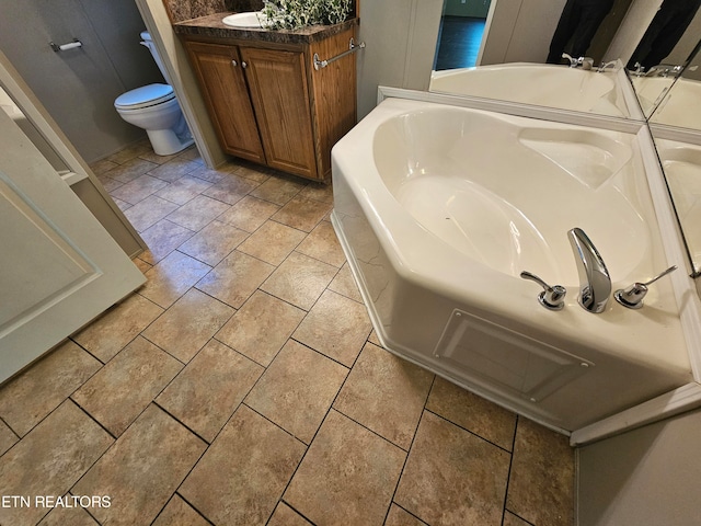 bathroom with vanity, a bath, and toilet