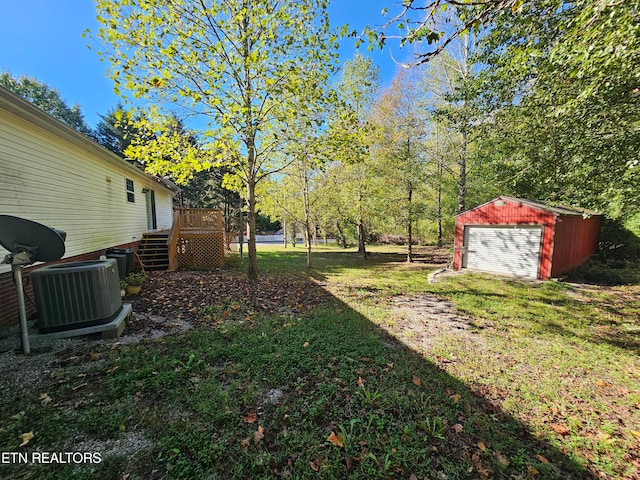 view of yard featuring central AC unit, a garage, an outdoor structure, and a deck