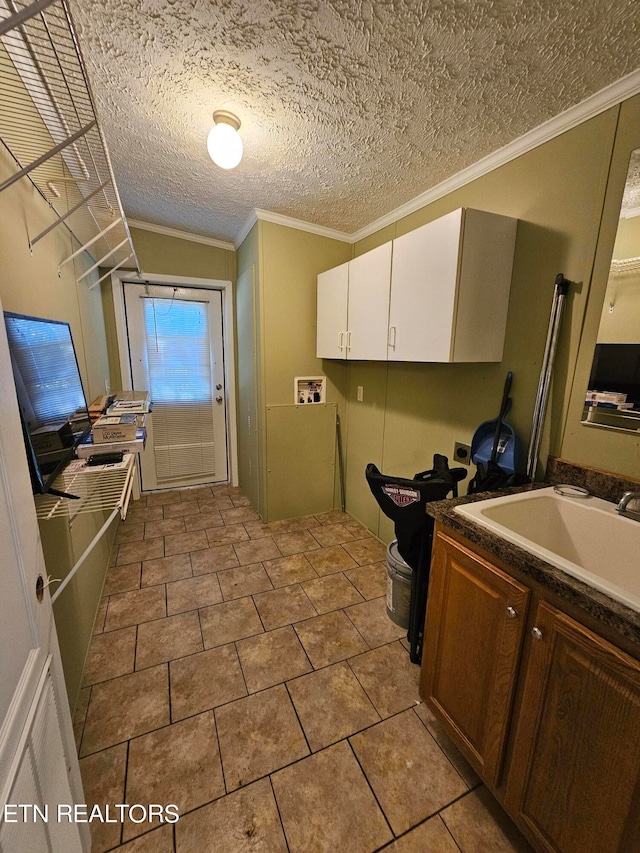 kitchen featuring white cabinetry, sink, and crown molding