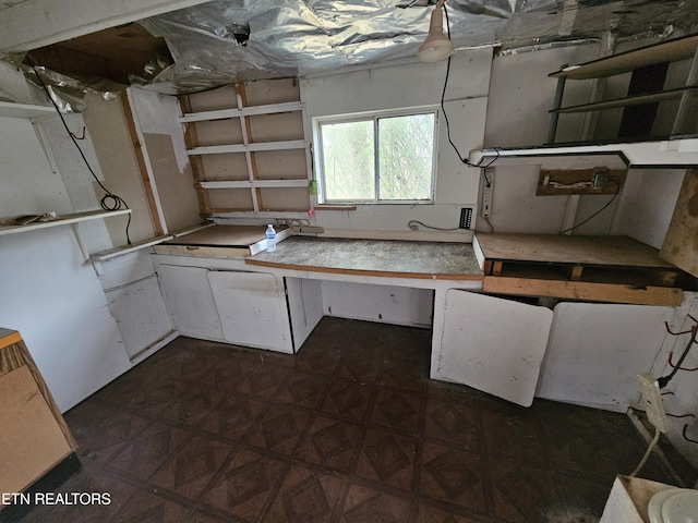 kitchen featuring white cabinetry and dark parquet floors