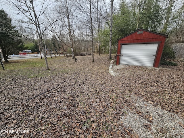 view of yard featuring a garage and an outbuilding