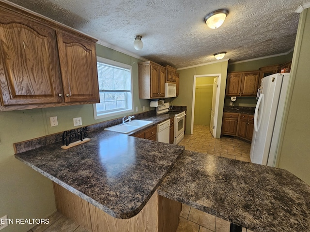 kitchen featuring white appliances, kitchen peninsula, and a textured ceiling