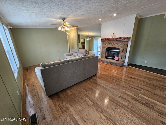 unfurnished living room featuring hardwood / wood-style flooring, plenty of natural light, a fireplace, and a textured ceiling