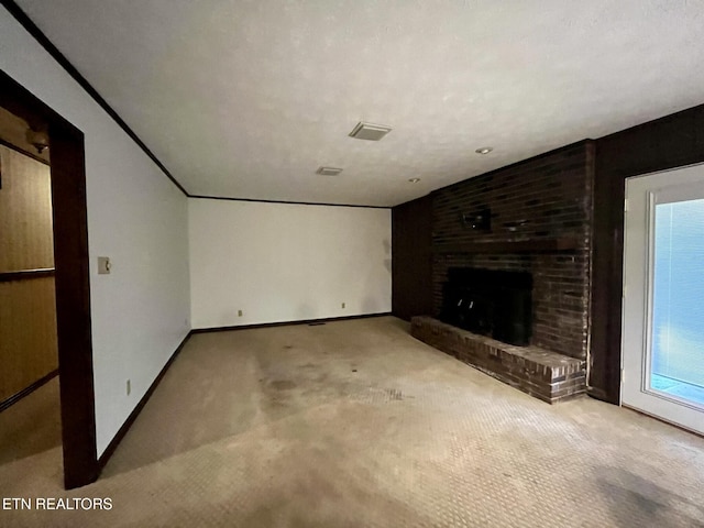 unfurnished living room with a brick fireplace, light colored carpet, and a textured ceiling