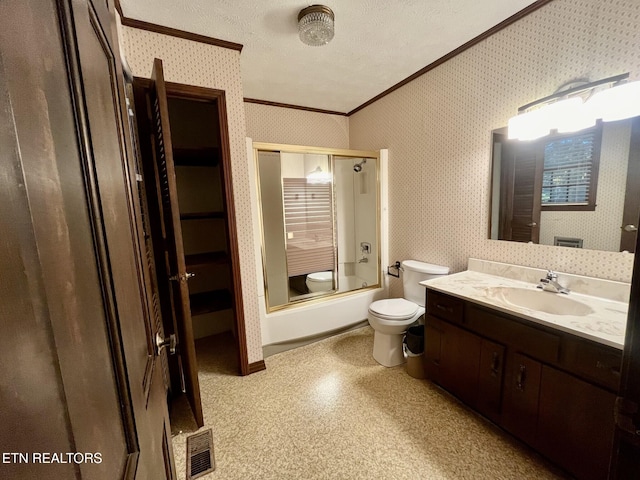 full bathroom featuring vanity, bath / shower combo with glass door, ornamental molding, toilet, and a textured ceiling