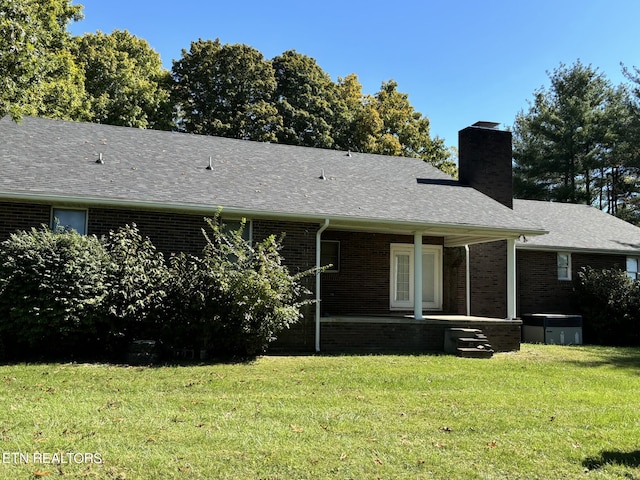 rear view of house featuring a lawn