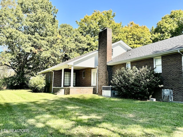 rear view of house with a yard and central air condition unit