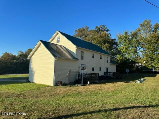 view of side of home with a yard