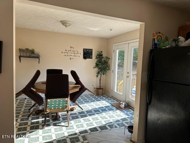 tiled office space featuring french doors and a textured ceiling