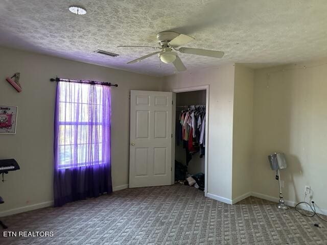 unfurnished bedroom with light carpet, a closet, a textured ceiling, and ceiling fan