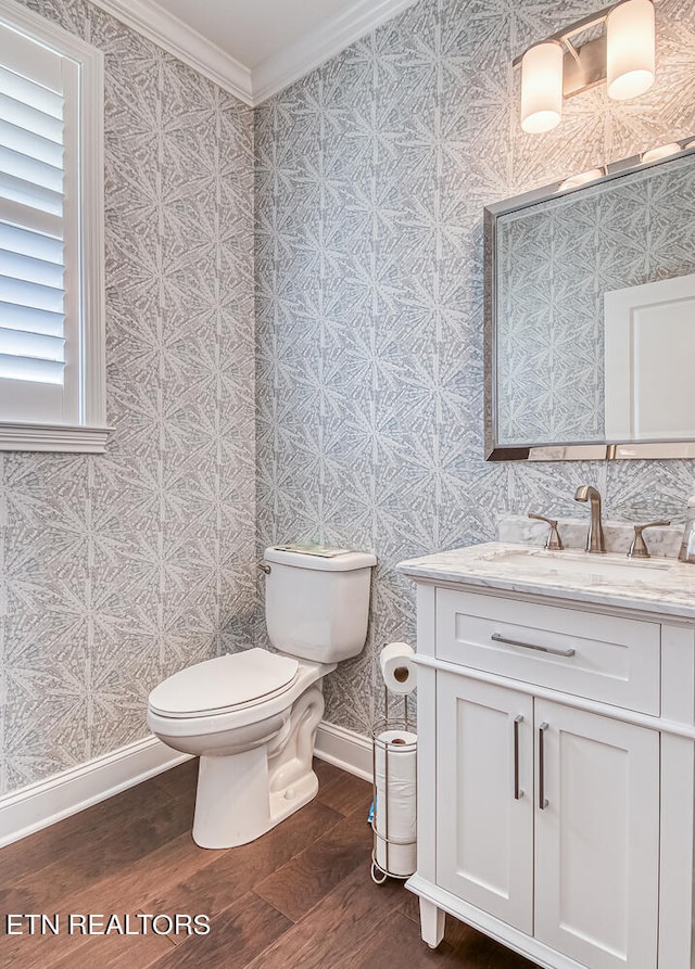 bathroom with crown molding, vanity, toilet, and wood-type flooring